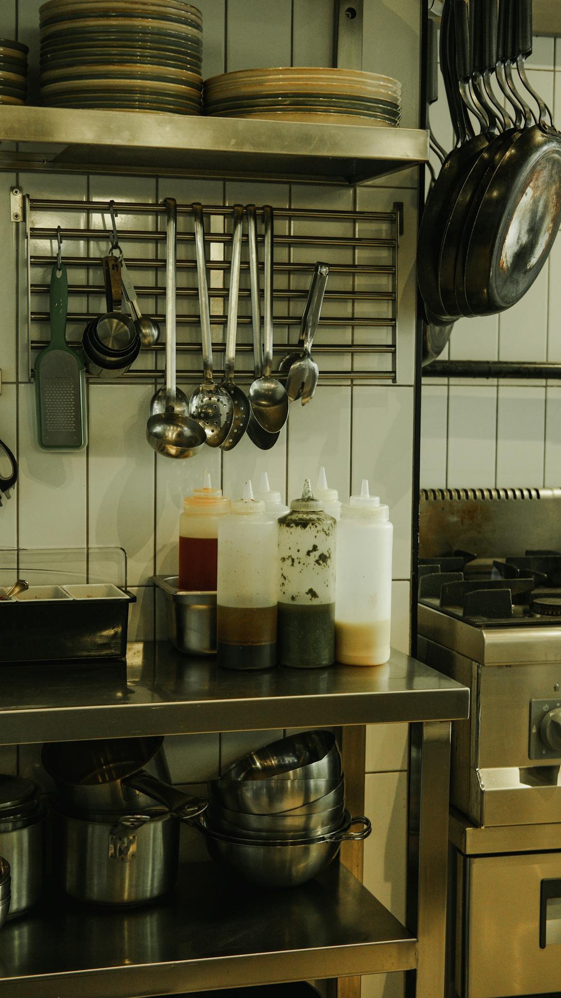 A modern industrial kitchen with stainless steel cookware and utensils, highlighting contemporary design.