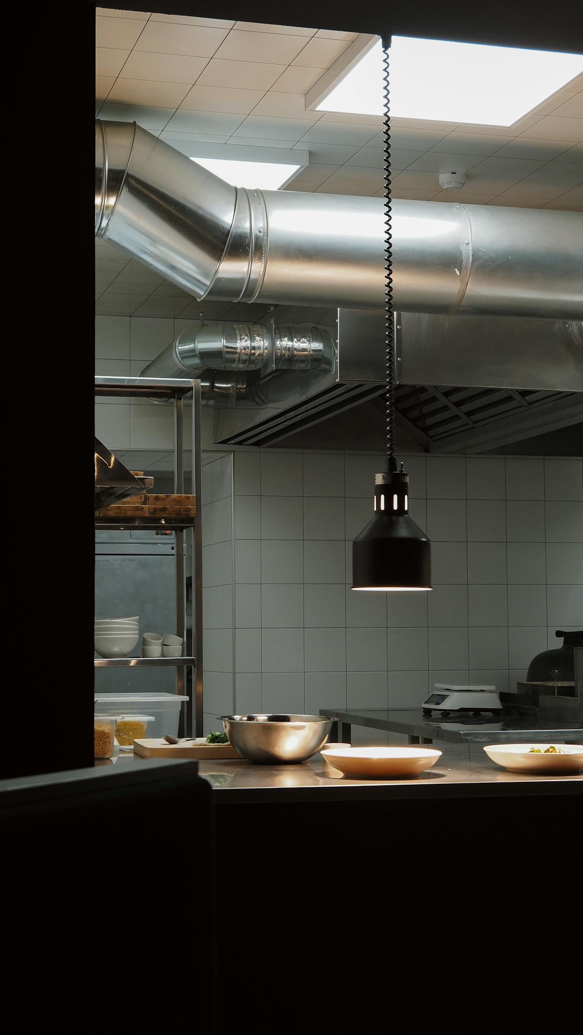 Stylish industrial kitchen setup with overhead lighting and modern fixtures.