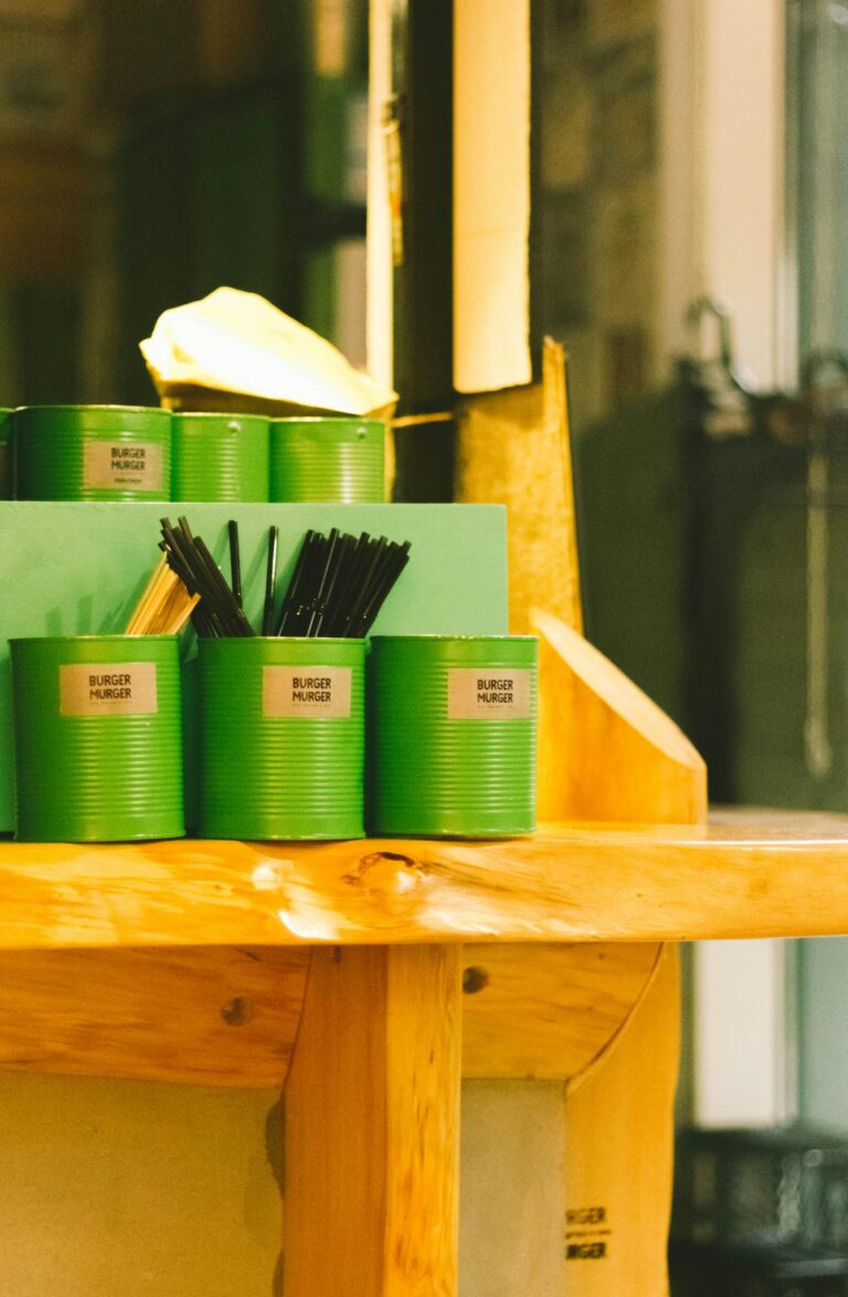 Stylish interior featuring green cans for straws on a wooden counter, a blend of modern design and functionality.